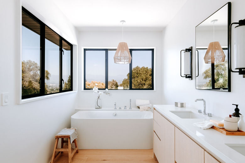 modern bathroom with black and white palette and pendant light above bathtub