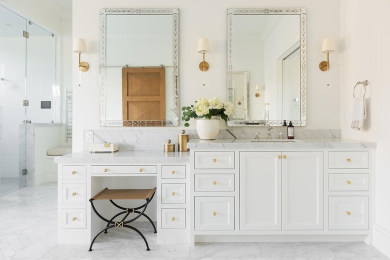 bathroom makeup vanity with white cabinets and marble countertop