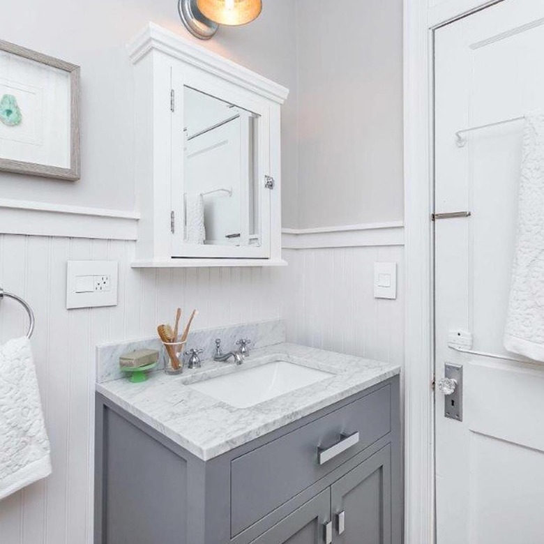 Bathroom organization idea with marble countertop and gray vanity cabinet