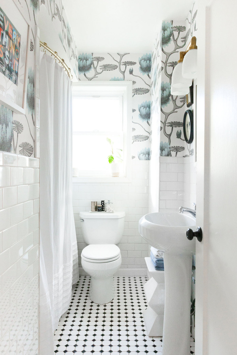 small bathroom organization idea with mosaic tile floor and subway tile wainscoting with patterned wallpaper above