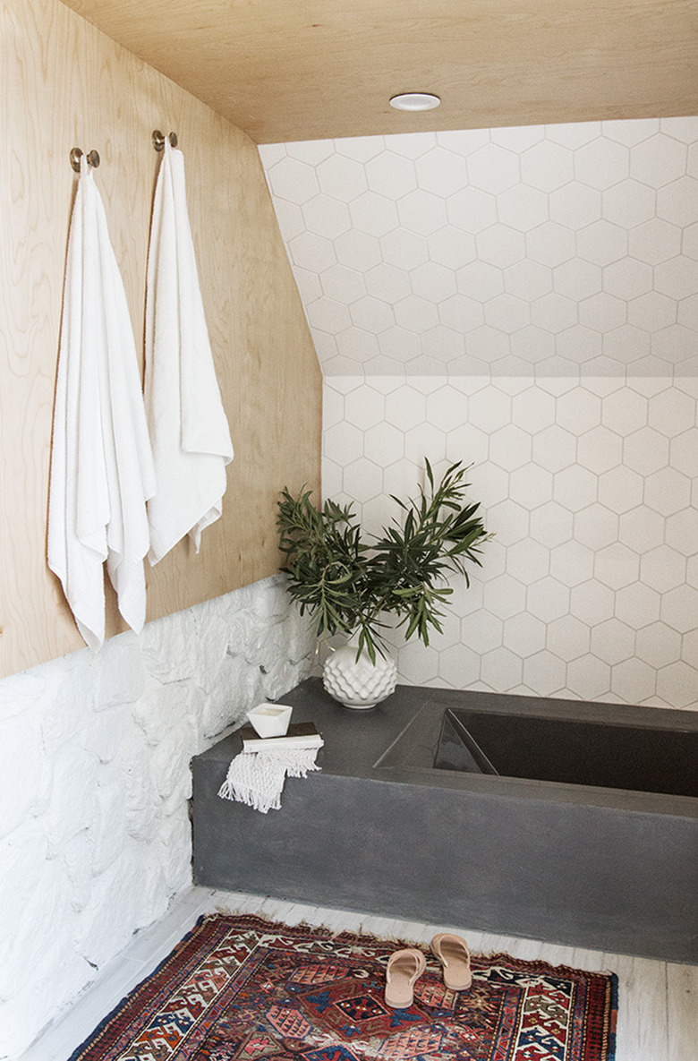 bathroom tile idea with white hexagonal tile on wall next to concrete tub