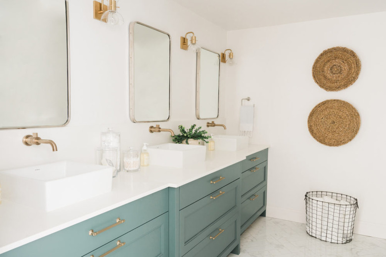 Pine bathroom cabinets with white walls and baskets on wall