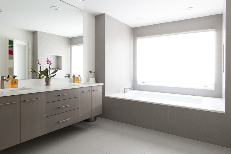 bathroom window with opaque covering and gray double vanity