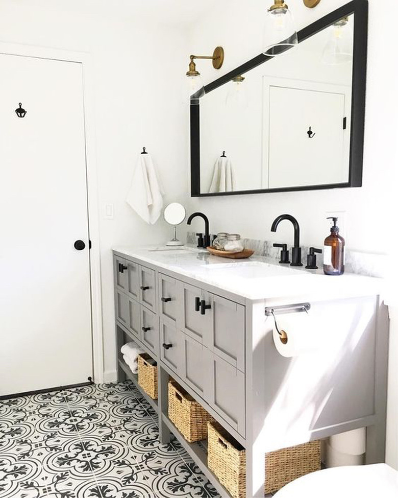 bathroom with gray vanity cabinet and black hardware