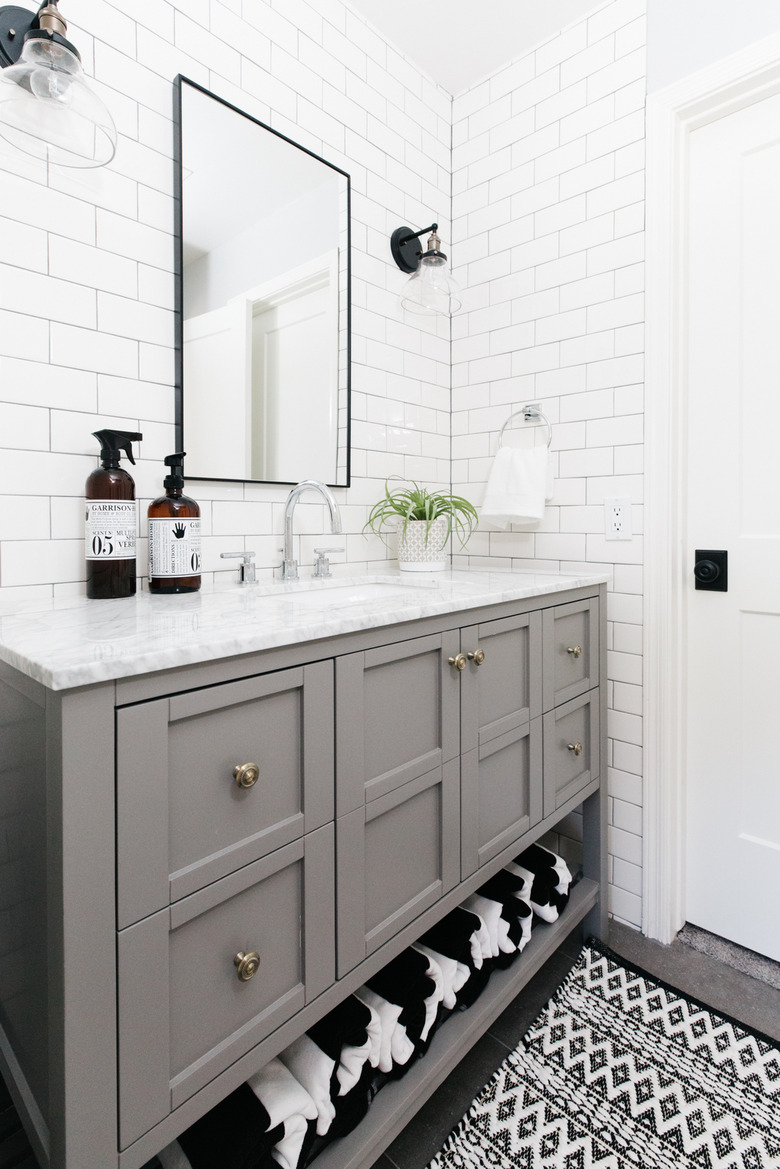 white bathroom with subway tile walls and gray vanity