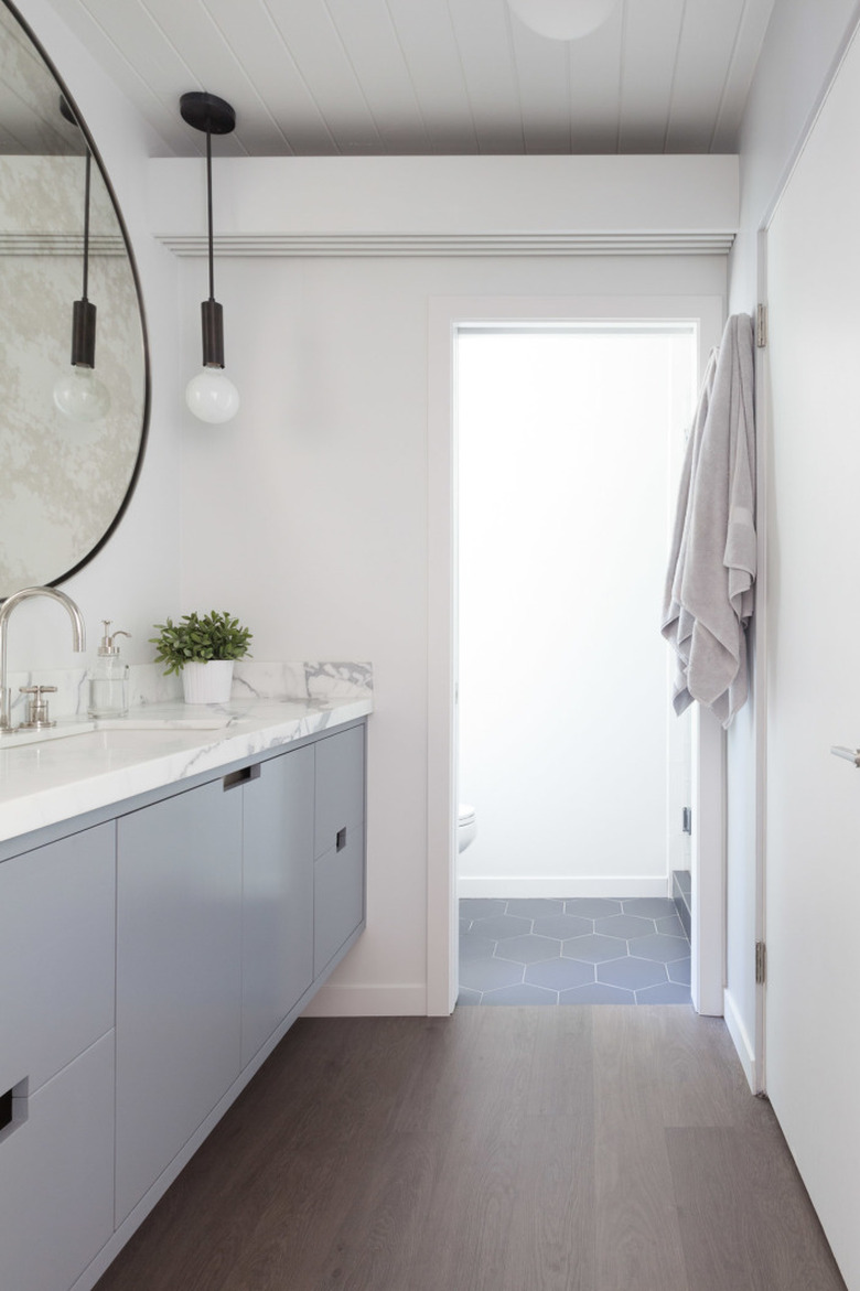 bright bathroom with white walls and gray vanity cabinet