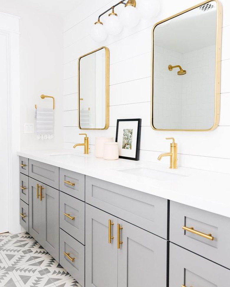 shiplap walls with gray vanity cabinet and gold fixtures