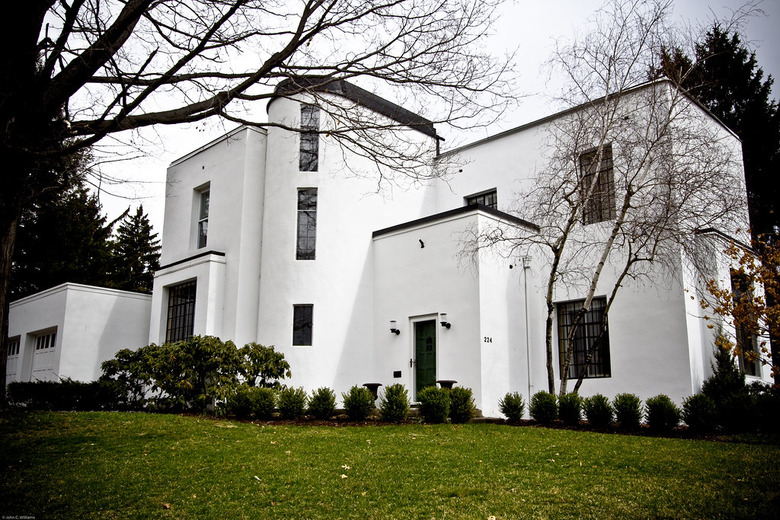 white Bauhaus house exterior with green yard and trees