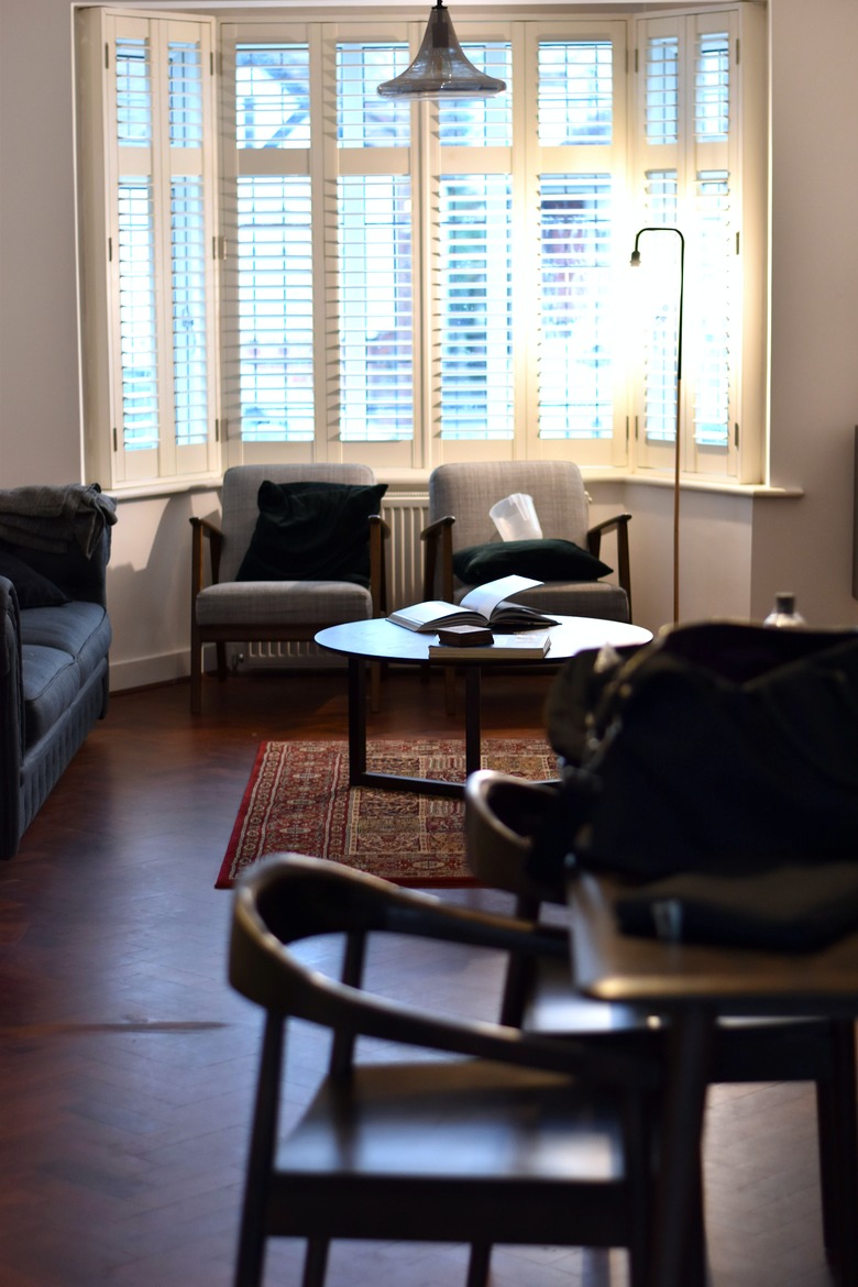 Living room den with matching arm chairs in bay window nook with bay window curtains