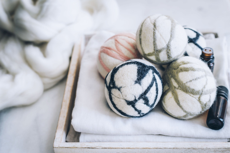 Wool felted dryer balls on tray with white cloth towels