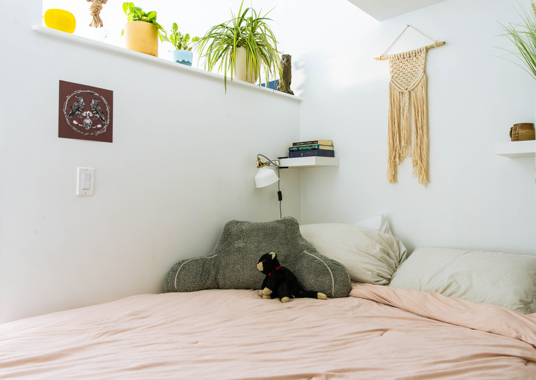 Bed with macrame hanging on wall