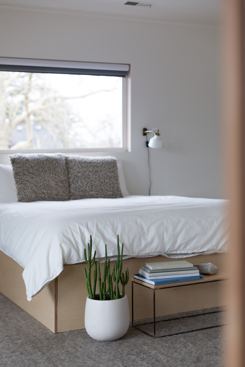 Bedroom with white bed and plant