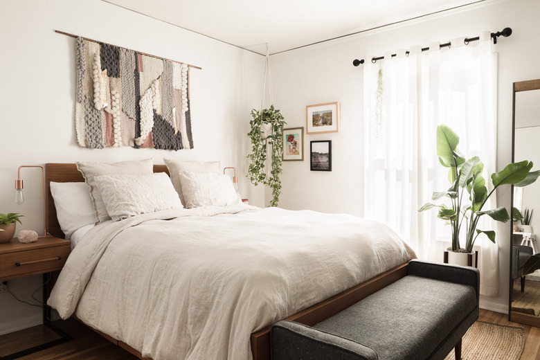 Boho bedroom with wall hanging over bed