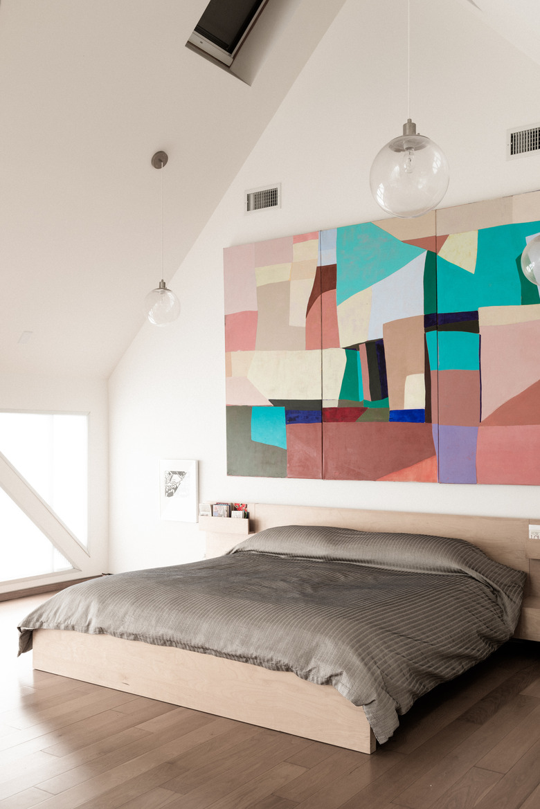 Bedroom with high ceiling and large wall art