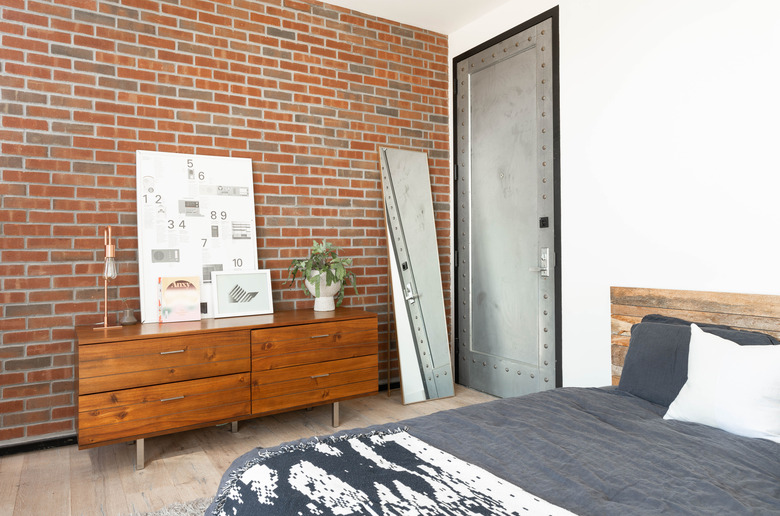 Bedroom with brick wall and industrial door