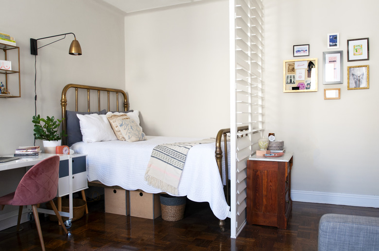 small bedroom idea with brass bed and plantation shutters.