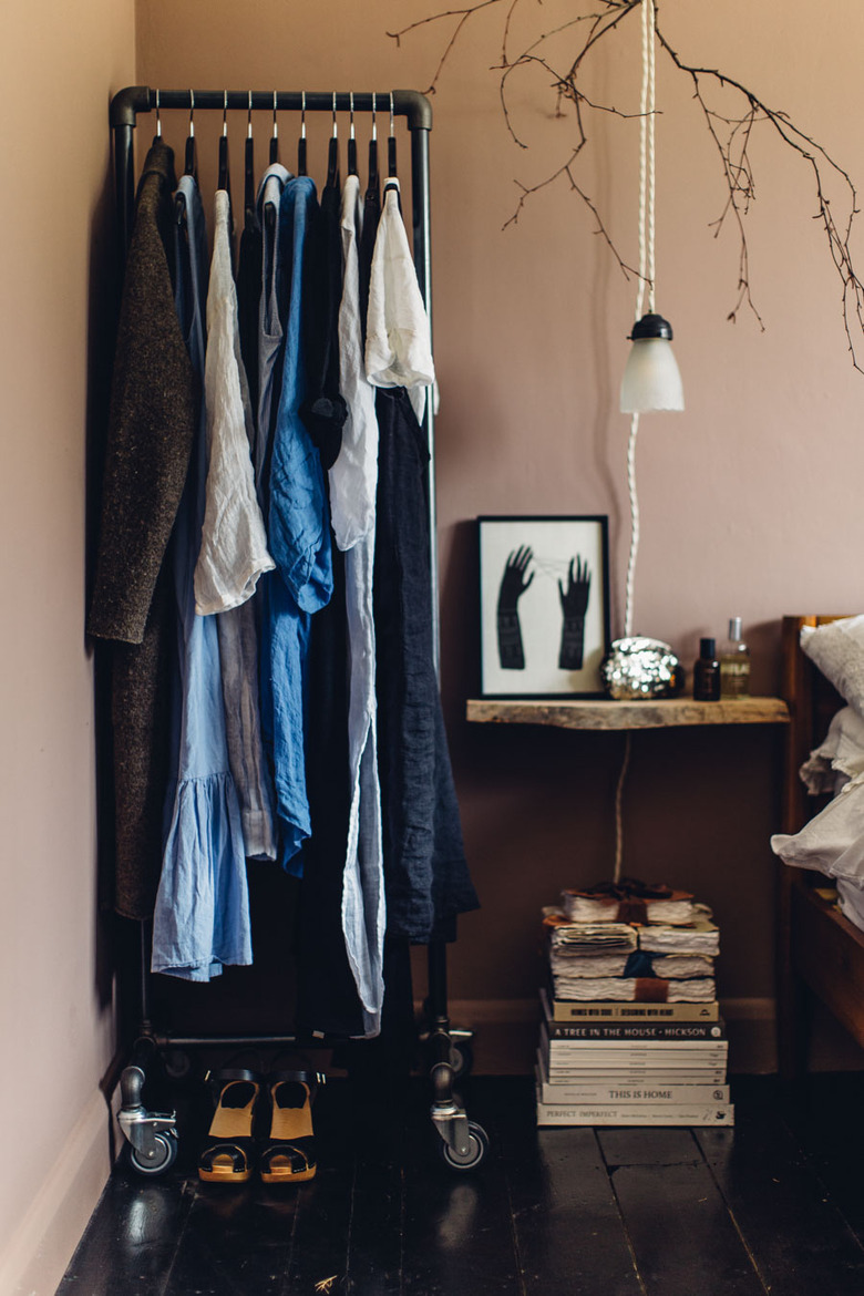 Bedroom storage idea with clothing rack next to bedside table