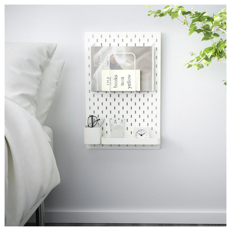 A pegboard beside a bed