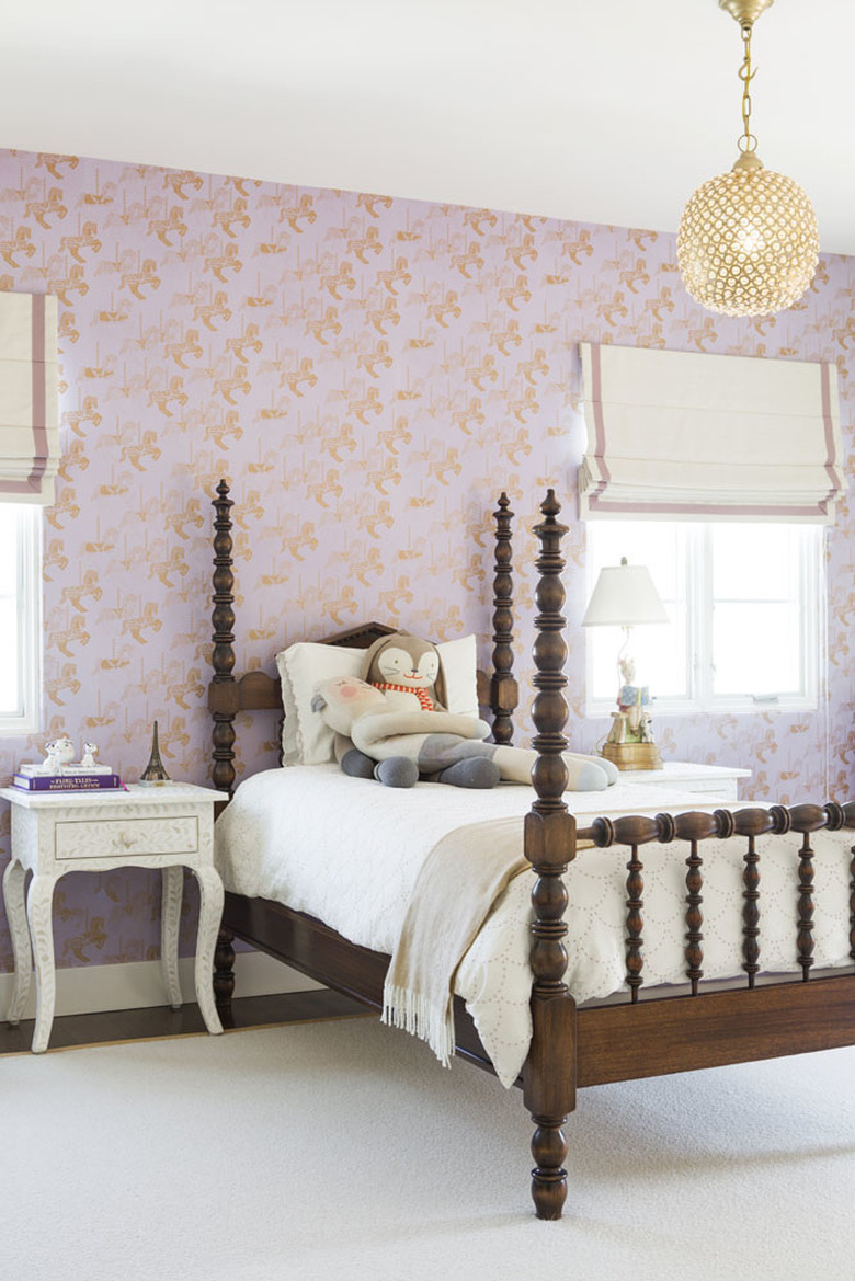 girls bedroom idea with pink patterned wallpaper and four poster bed