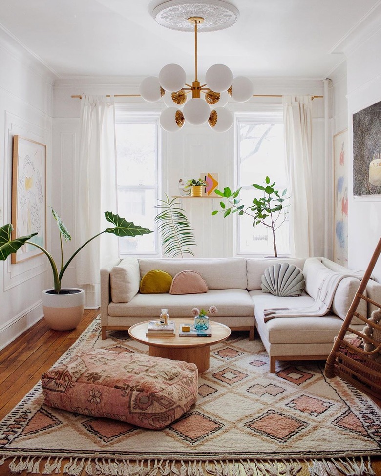 sunset-inspired white living room with midcentury chandelier and sectional sofa