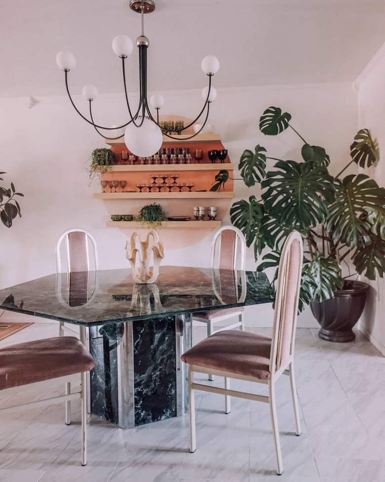 Dining room with sunset-inspired shelving accent and geometric marble dining table