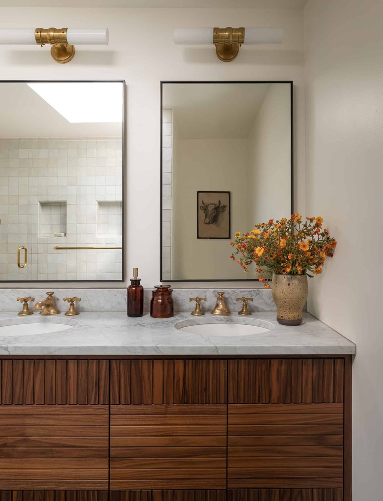 beige color bathroom with wood and marble double vanity and glass mirrors