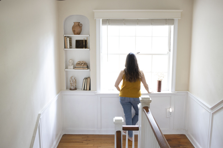 Woman looking out of a bay window