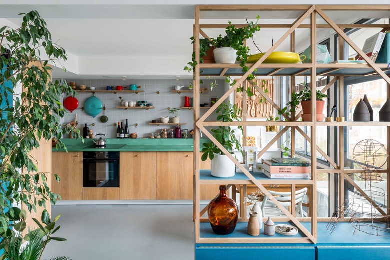 The kitchen of architect Ben Allen's London home featuring shelves and bright blue accents