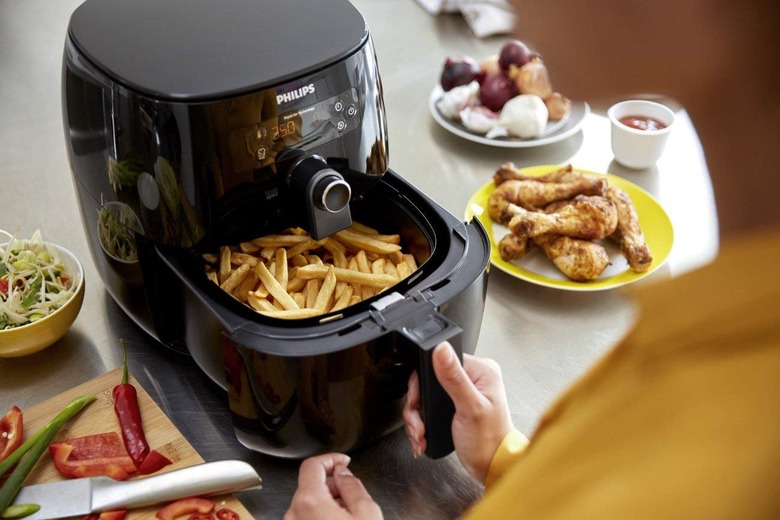 Black air fryer with fries in basket