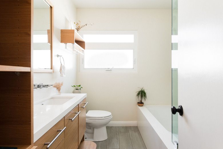 bathroom with tub/shower combo, toilet and one sink. Window above the toilet