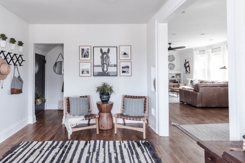 Minimalist living room with white ceiling, white wall paint and dark wood floors.