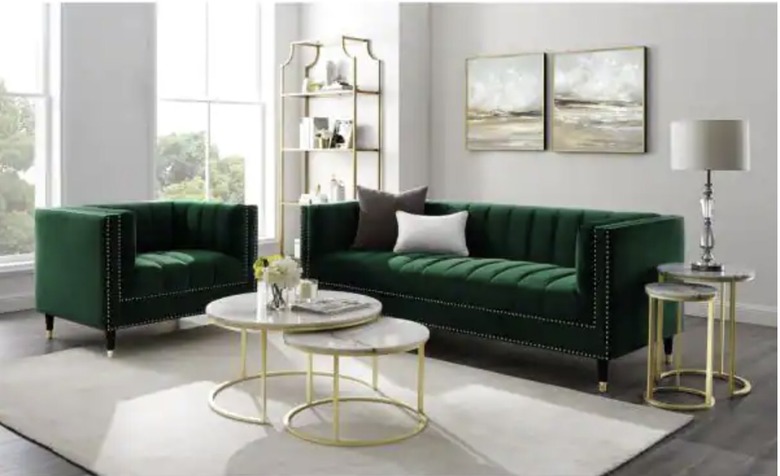 White room with green velvet couches and ivory rug and gold accents