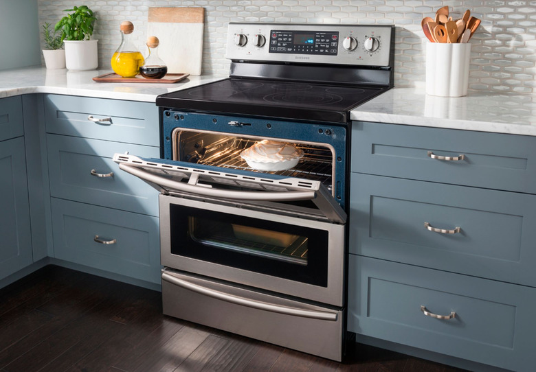 electric stove in a blue kitchen with open oven door