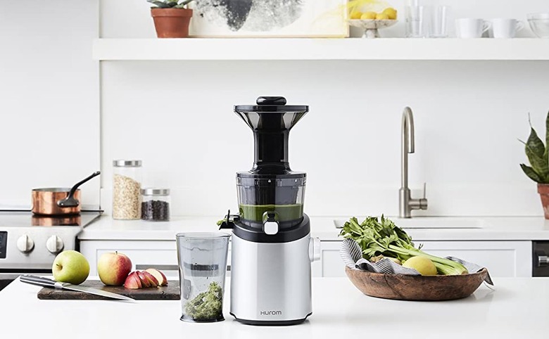 Hurom juicer with fruits and vegetables in kitchen