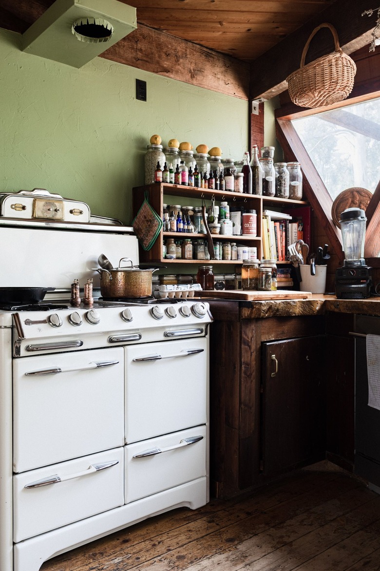 Green wall kitchen with a wood ceiling, floor, and cabinets, and a retro stove.