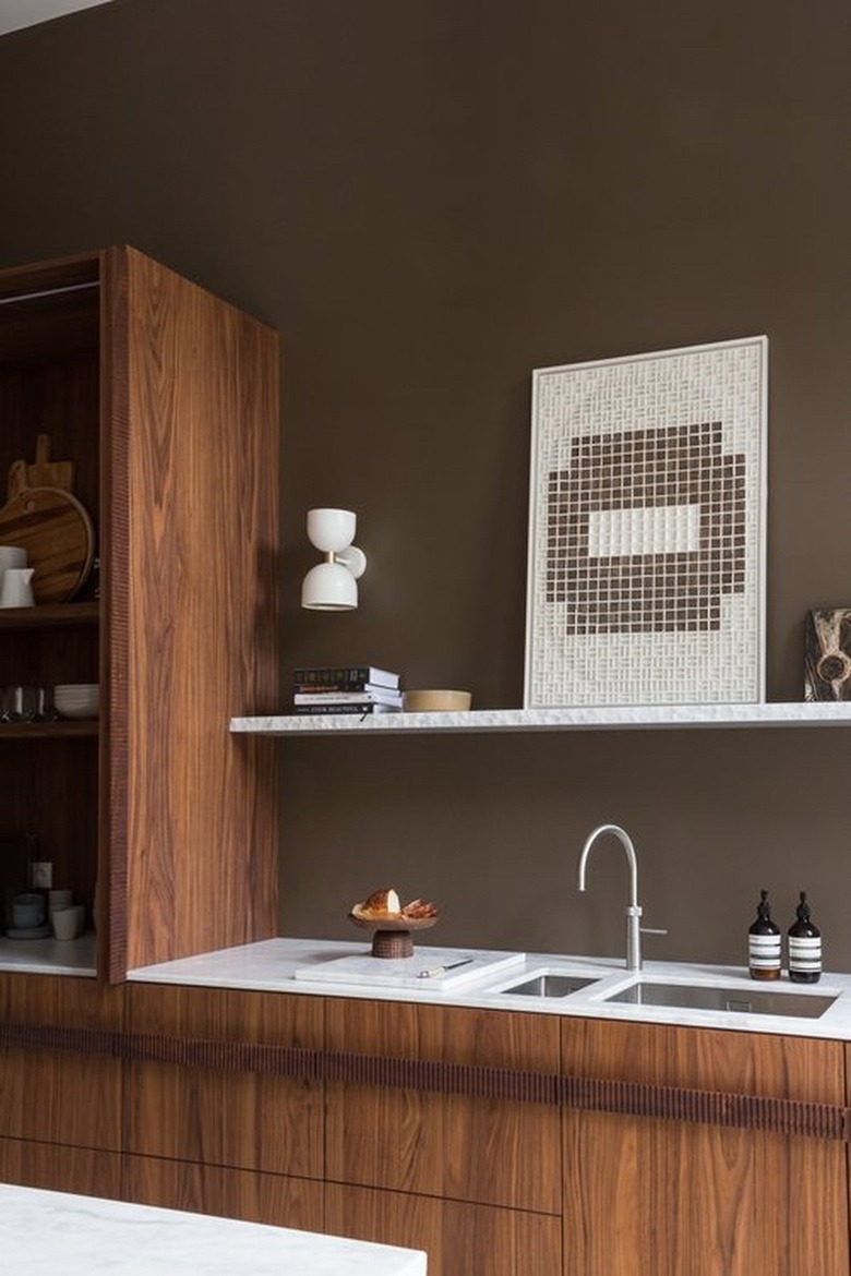 brown kitchen walls with wood cabinetry and slim marble countertop