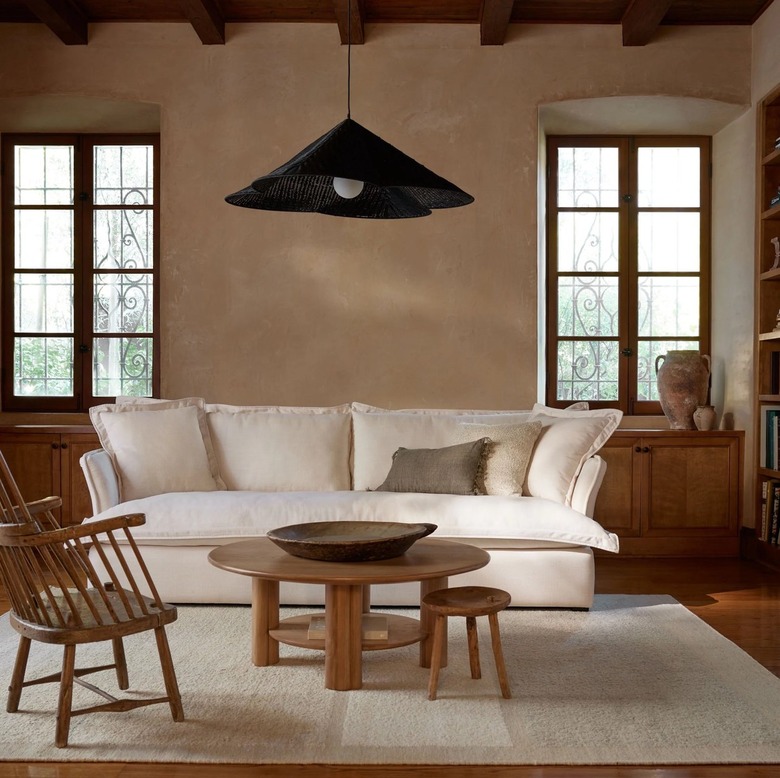 living room with white couch and cream rug and black abstract chandelier