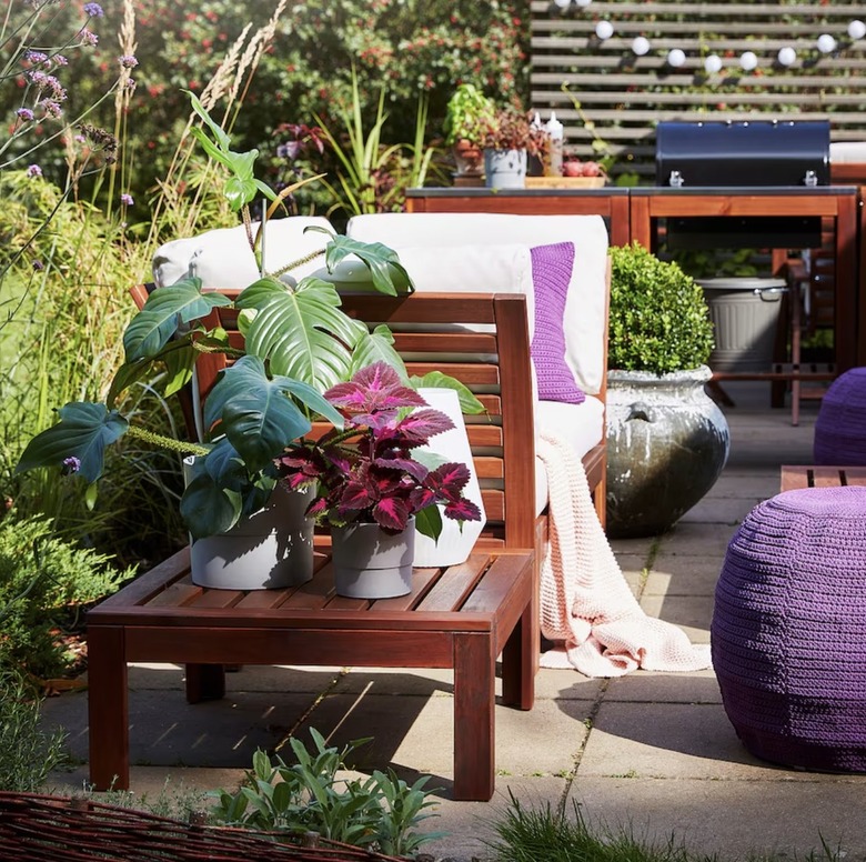 Wooden side table with plants on top in garden