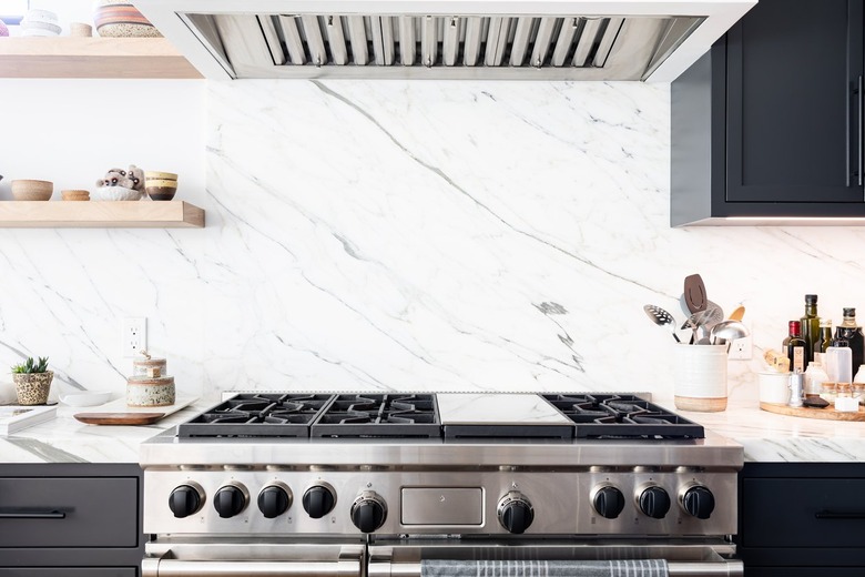 Kitchen stove with white granite countertops and wood shelves