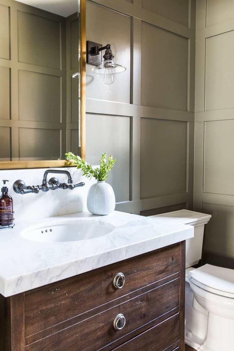 Taupe color in bathroom with wall panels and gold vanity mirror