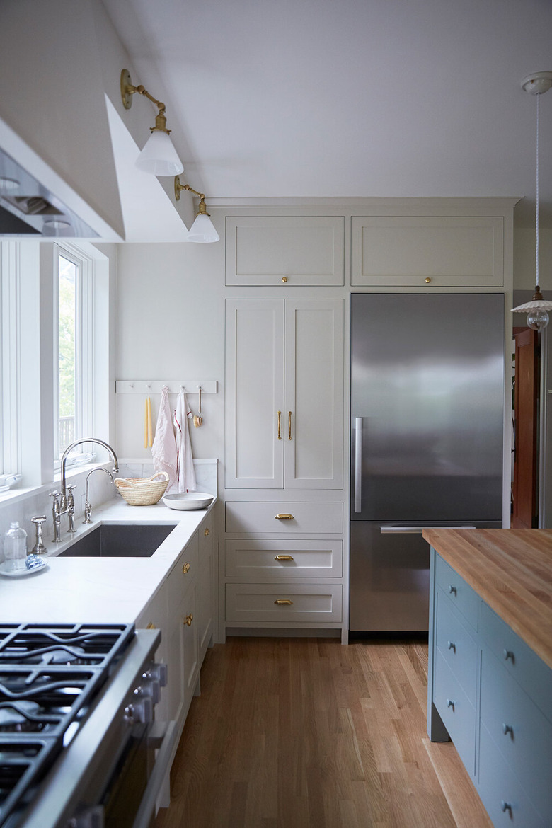 Taupe colors in kitchen with blue island and wood floors