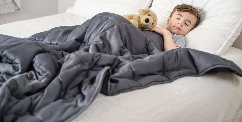 Child sleeping under weighted blanket.