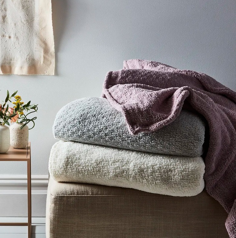 Stack of three weighted blankets, flowers, vases.