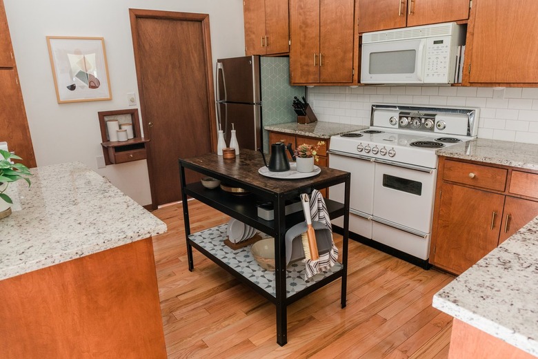 Black farmhouse workbench with dishware in wood cabinet kitchen