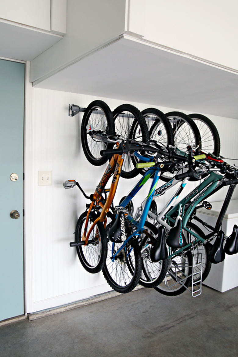 bike storage rack on the wall in garage next to blue door