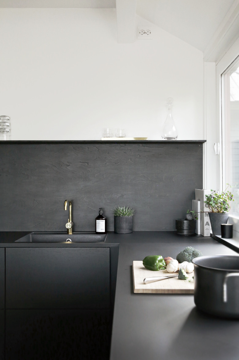 black and white kitchen with black backsplash and sink