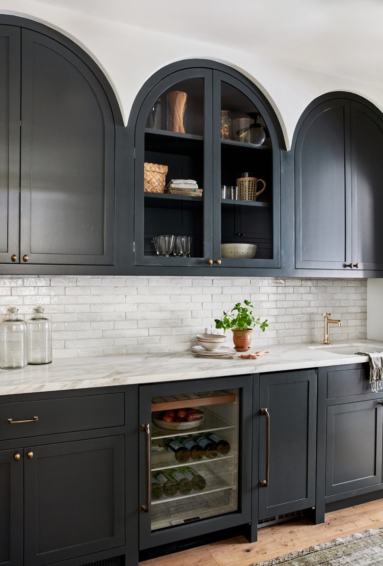 black and white kitchen with arched upper cabinet design