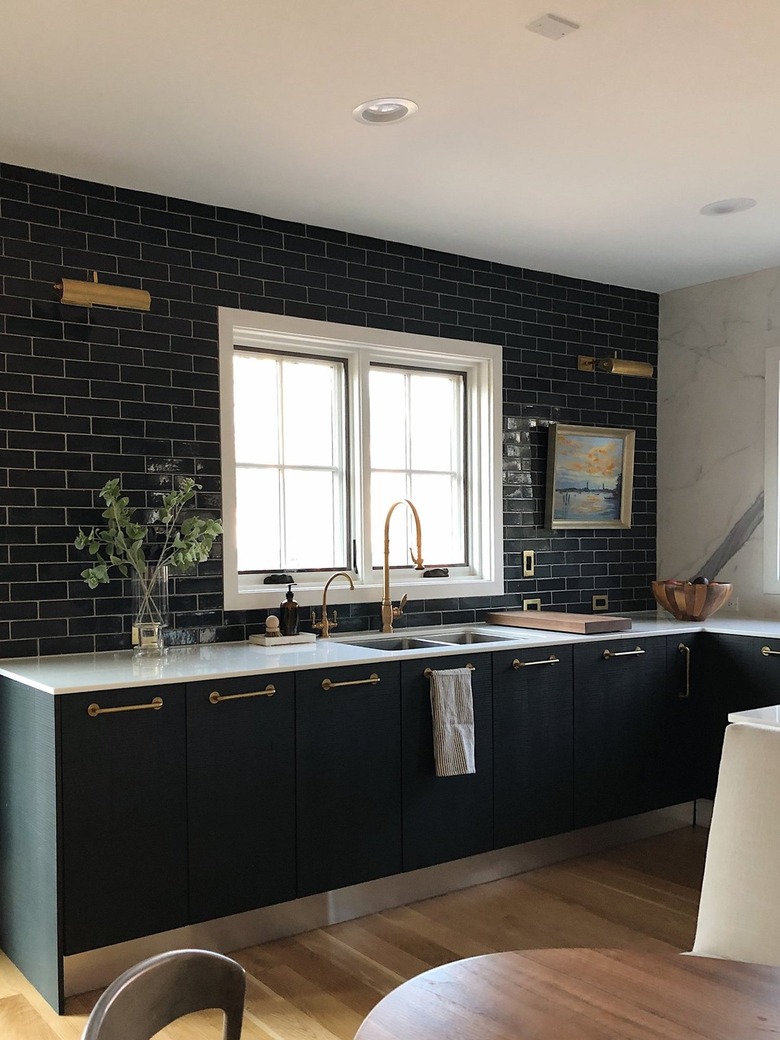 all black kitchen with white counter and wood floors