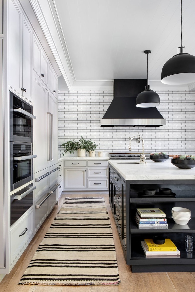 white kitchen with black grout lines and black pendant lights