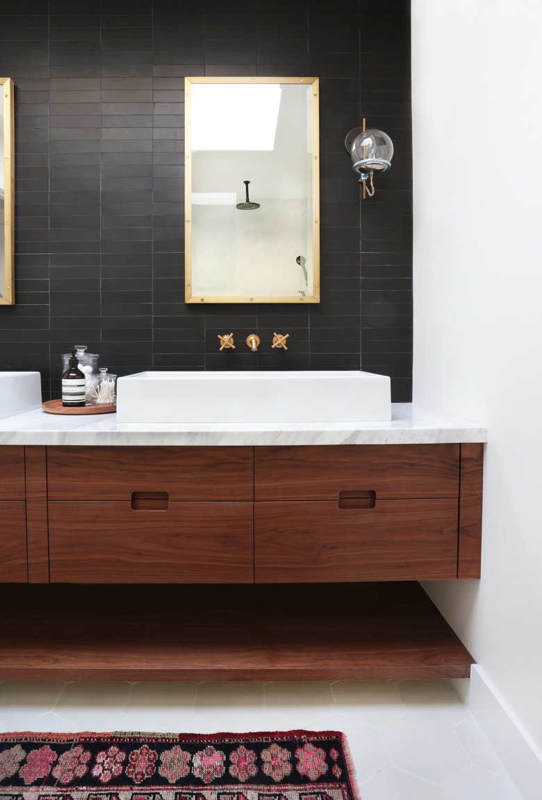 Black bathroom backsplash idea with subway tile in straight lay pattern, gold hardware